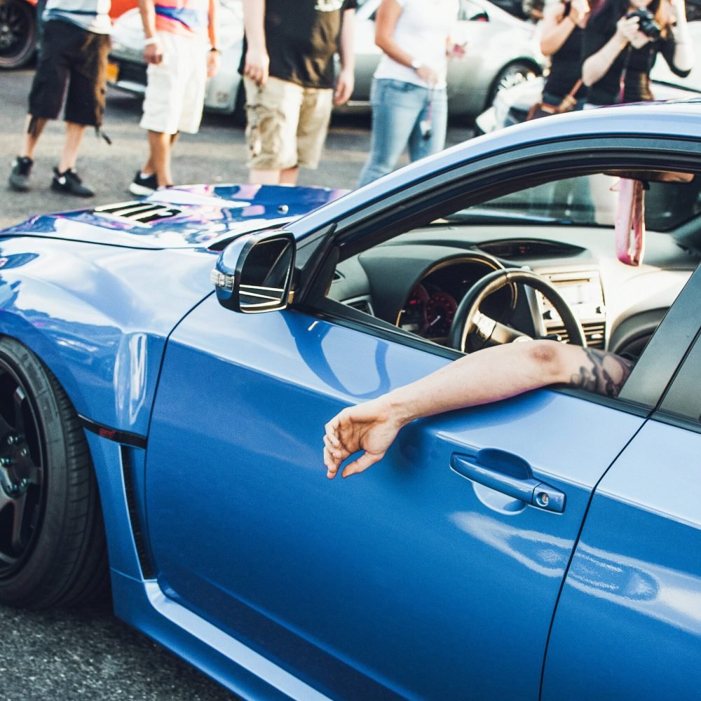 Man sits in blue BMW on the street